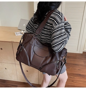 Détail du sac cabas en cuir marron foncé avec rivets étoiles et bandoulières réglables