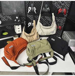 Detailed close-up of nylon crescent crossbody bags in five colors with adjustable straps