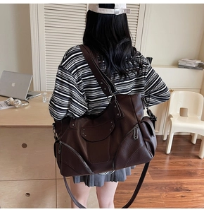 Détails du sac cabas en cuir marron foncé avec rivets et poches zippées argentées