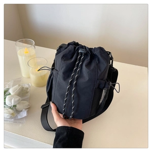Detail der schwarzen Nylon-Beuteltasche mit Kordelzug, Netzseitentasche und Webseil