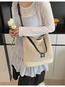 Sac de plage tressé beige avec bandoulière en cuir noir et plaque de logo de marque