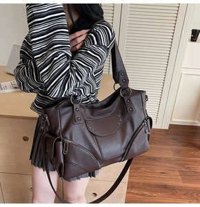 Détail latéral du sac cabas marron foncé à rivets avec texture en cuir grainé de litchi