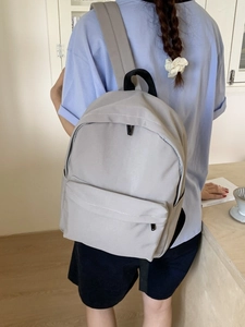 Minimalist grey large capacity backpack with black top handle for daily students use