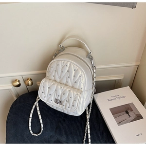 Detailed macro view of white quilted mini backpack with sparkling crystal rhinestones
