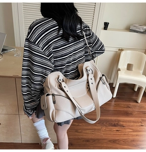 Sac fourre-tout blanc à rivets style moto avec étoiles cloutées dans un décor de bureau