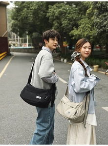 Detail of black and beige nylon messenger bags showing large capacity and adjustable straps