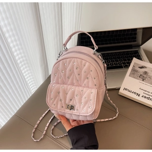 Detailed shot of pink quilted leather backpack with sparkling rhinestones and metal lock