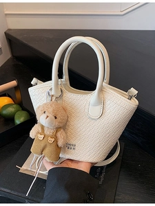 Sac seau blanc tissé chic avec charm d'ours et poignée supérieure pour femmes