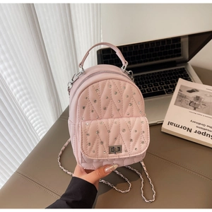 Detail of pink quilted mini backpack with sparkling rhinestones and silver chain strap