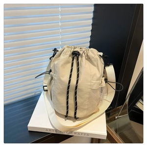 Detailansicht der beigen Nylon-Beuteltasche mit Netztasche und gestreiftem Kordelzug