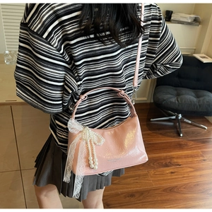 Sac à bandoulière rose brillant avec nœud perlé et ruban en dentelle sur mannequin