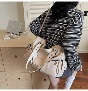 Détail du sac cabas moto à rivets en cuir grainé beige avec garniture argentée