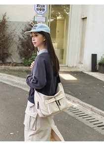 Detail of beige nylon crossbody bag featuring functional multi-pockets and spacious design