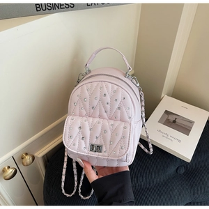 Close-up of pink quilted backpack with crystal diamond embellishments and silver chain