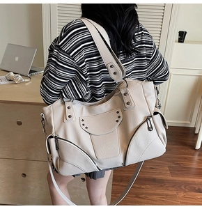 Détail du sac cabas texture litchi avec rivets en étoile et fermetures éclair en métal