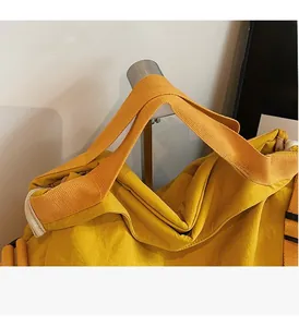Detail der verstärkten gelben Nylon-Tragegriffe an einer großen Freizeittasche