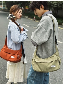 Outdoor street style view of large nylon crossbody bags in vibrant orange and khaki green