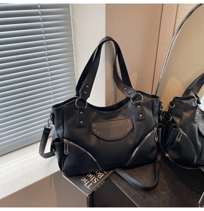 Détail d'un cabas en cuir noir grainé avec rivets étoiles et fermetures zippées