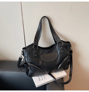 Détail du sac cabas en cuir noir avec rivets argentés et ornements en métal étoilé