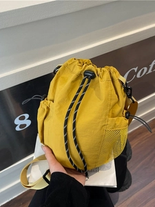 Gelbe Nylon-Beuteltasche mit Kordelzug und seitlichem Netzfach für den täglichen Gebrauch