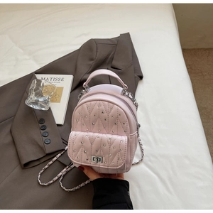 Detail of pink quilted PU leather mini backpack with sparkling rhinestones and silver chain