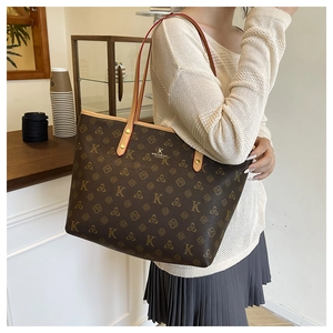 Detail of the high-capacity tote bag featuring luxury monogram pattern and leather straps