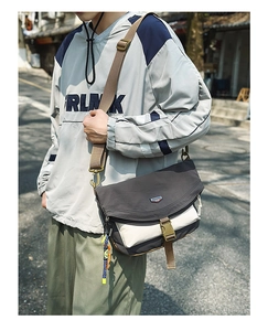Detail of the dual-tone nylon crossbody bag showing the yellow buckle and woven strap