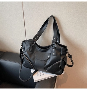 Détail du cuir grainé noir et des rivets en forme d'étoile sur le sac à main