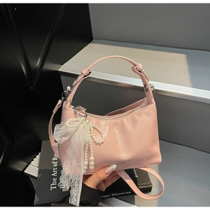 Détail du sac à main en cuir PU rose avec nœud perlé et gland en dentelle