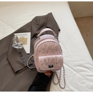 Close-up of pink quilted backpack with rhinestone details and silver chain strap