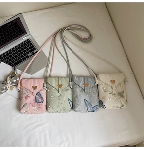 Détails de broderie papillon florale et fermoir coeur doré sur mini sacs à bandoulière