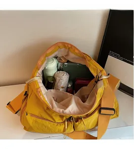 Detailansicht der großen senfgelben Tasche mit Innenraum für Tablet, Flasche und Regenschirm