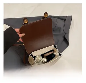 Detail of the interior storage compartment in a cream British style satchel with brown flap