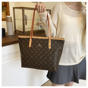 Detail of dark brown patterned tote bag with leather handles in a cafe setting