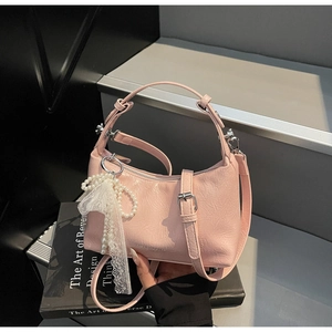 Détails d'un sac à main plissé rose avec charm en dentelle perlée et ferrures argent