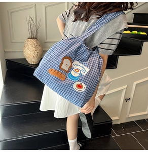 Detail of blue plaid canvas tote bag with cute bread and coffee afternoon tea patches