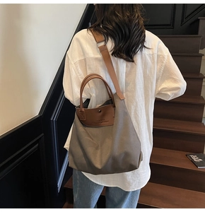 Gray canvas tote bag detail showing brown leather straps and large interior for commuting