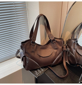 Détail du sac cabas marron foncé avec rivets étoilés et texture cuir en reflet miroir