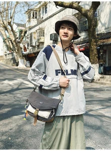 Detail of grey windproof hoodie and nylon messenger bag for outdoor street style