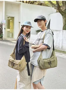 Detail showing khaki and army green nylon cross-body bags with dual front pockets