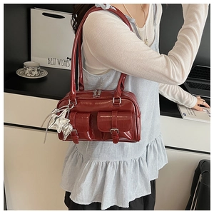 Nahaufnahme der burgunderroten Bowlingtasche aus Lackleder mit Sternanhänger-Detail