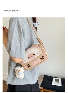 Modella che indossa una borsa rosa a forma di gatto con ciondolo a forma di orso