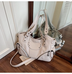 Détail du sac cabas crème avec rivets en étoile et texture en similicuir grainé