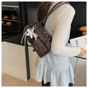 Detailaufnahme der braunen Krokodilledertasche mit mehreren Taschen und Sternenanhängern
