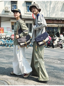 Detail of color-block nylon messenger bags with adjustable straps in outdoor street setting