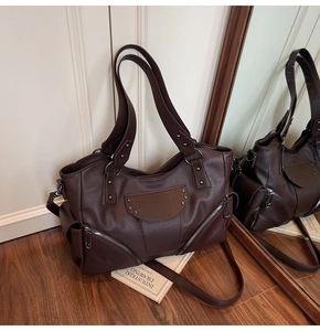 Vue détaillée du sac cabas moto vintage marron foncé avec rivets étoiles et fermetures argent