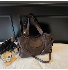 Détails du sac cabas en cuir marron foncé avec rivets en étoile et finitions métal noir