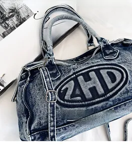Dettaglio della borsa tote in denim blu lavato con logo ZHD ricamato e manici robusti