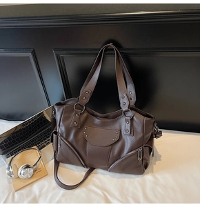 Détails de la texture en cuir grainé marron foncé avec rivets étoiles du sac cabas