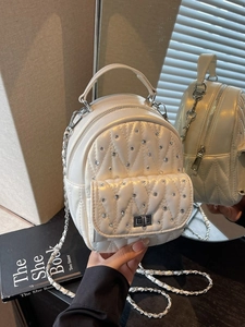 White quilted mini backpack with rhinestone embellishments and elegant chain straps